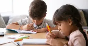 Two children studying together at home, focused on their schoolwork.